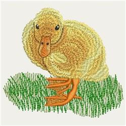 Applique yellow duckling with orange beak standing on bright green grass, whimsical and playful design.