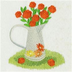 Colorful floral arrangement featuring vibrant orange roses in a white pitcher on lush green grass.