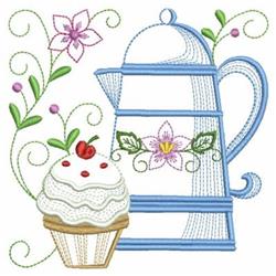 Whimsical teapot in blue with floral designs, beside a cupcake with white frosting, perfect for spring.