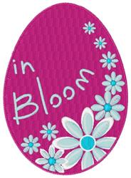 Playful decorative egg in pink featuring light blue and white flowers and the phrase 'in Bloom', perfect for spring.