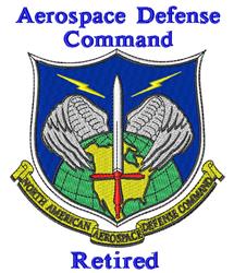 Aerospace Defense Command emblem featuring a shield design with a blue background, green globe, red sword, and white wings.