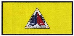 Vibrant sailing triangle emblem with a red and dark blue sailboat on a bright yellow background.