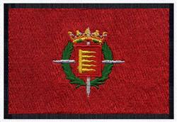 Bold emblem with shield featuring a stylized 'E', gold crown, green laurel wreath, and swords on a textured red background.