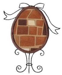 Applique decorative egg with whimsical patchwork design in brown shades, on wire stand with bow, perfect for Easter.