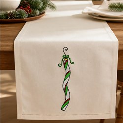 Candy cane table runner with whimsical red and green swirls, perfect for festive Christmas decor.