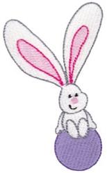 Whimsical rabbit with pink-tipped ears sitting on a purple ball, perfect for cheerful Easter embroidery.