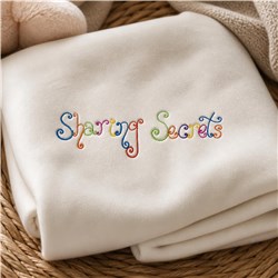 Text design 'Sharing Secrets' in colorful, curly lettering on a soft, neutral blanket, creating a playful ambiance.