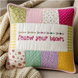 Colorful decorative pillow with patchwork and whimsical embroidery saying 'FOLLOW YOUR HEART' in pastel shades.