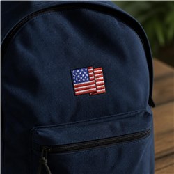 Embroidered American flag on a navy backpack, showcasing detailed stars and stripes, perfect for Independence Day.