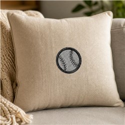 Baseball pillow featuring a circular baseball embroidery design with distinct stitching, set in a cozy neutral decor.
