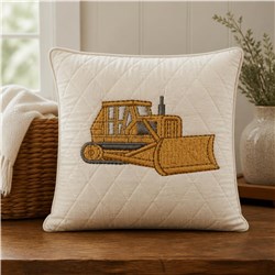 Realistic bulldozer in yellow and gray, embroidered on a cream quilted pillow, showcasing intricate detail.