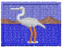 Crane by the water with orange legs, vibrant blue backdrop, brown mountains, and clear sky.