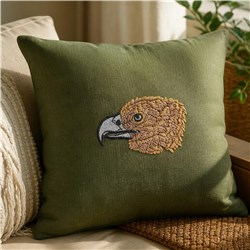 Realistic eagle head on a green pillow, featuring intricate embroidery of the bird's beak and feathers.