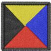 Geometric patch design featuring a square with yellow, blue, red triangles, and a bold black border.