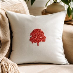 Cozy decorative pillow with a red embroidered tree on light fabric, set on a beige sofa for fall.
