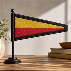 Modern triangular flag in red and yellow, bordered by black, on a sleek black stand, enhancing a cozy indoor setting.