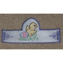 Colorful applique yellow chick beside a pastel Easter egg, with flowers and grass in a playful spring scene.