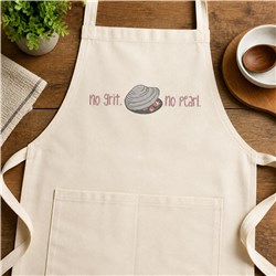 Cream-colored apron with playful clam shell and 'no grit. no pearl.' text on a wooden surface, perfect for rustic kitchens.