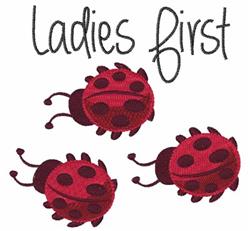 Playful red ladybugs with black spots surround the phrase 'Ladies first' in a cheerful design, perfect for embroidery.