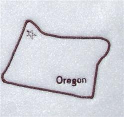 Simple outline of Oregon in dark brown thread on white fabric, featuring a star symbol and 'Oregon' text.