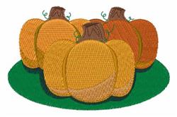 Vibrant cluster of pumpkins with textured surfaces in shades of orange and yellow atop green grass, perfect for fall décor.