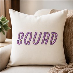 'SQUAD' text pillow in purple with polka dots on a cream background, adding a playful touch to a cozy couch.