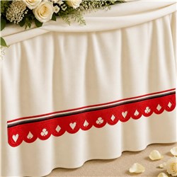 Elegant cream table skirt with red scalloped trim and heart shapes, perfect for wedding decor.