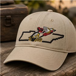 Playful baseball cap in light tan with cartoon characters embroidered on the front, resting on wood.