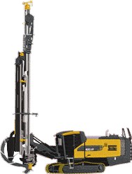 Industrial drilling machine in yellow and black with a tall drill, metallic details, and robust tracks for mobility.