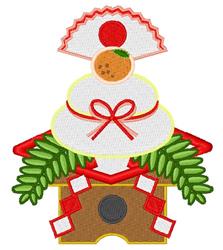 Colorful stack of white rice cakes topped with a golden tangerine, adorned with green pine leaves and red ribbons for festive