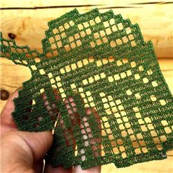 FSL leaf design in vibrant green lace, held delicately to showcase its intricate pattern against wood.