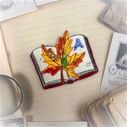 FSL open book with a colorful autumn leaf, vibrant 'A' in blue, whimsical fall design.