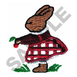 Whimsical brown rabbit in a red and white checkered dress, holding a flower on green grass for Easter decor.
