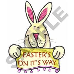 Whimsical rabbit holding a yellow banner reading 'EASTER'S ON IT'S WAY', perfect for festive Easter decor.