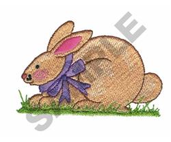 Playful rabbit with a brown body and purple bow on green grass, perfect for Easter celebrations.