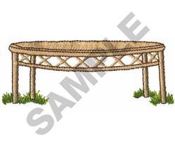 Rounded table with a woven light brown texture, elevated on four legs, surrounded by green grass.