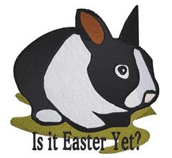 Cute cartoon-style rabbit in black and white resting on green grass with the text 'Is it Easter Yet?' above.