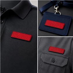 Red embroidered patches on a black collared shirt and dark navy badge holder, showcasing modern flair.