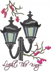 Colorful lamp post with two black lanterns and delicate pink flowering branches, perfect for spring decor.