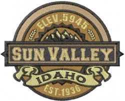 Vintage badge featuring 'SUN VALLEY' in bold text, adorned with mountains and laurel leaves, in warm earth tones.