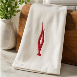 Redwork abstract flame design on a white towel, folded on wood. Simple and modern with vibrant red embroidery.
