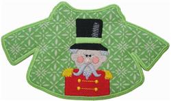 Applique Nutcracker in red uniform and black hat, features rosy cheeks on a vibrant green background, perfect for Christmas.