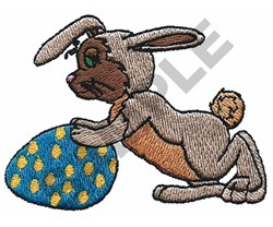 Playful rabbit in brown and grey crouched over a blue Easter egg with yellow polka dots, perfect for festive projects.