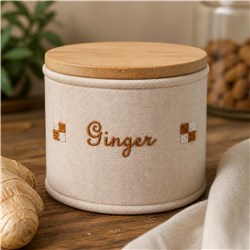 Round beige container labeled 'Ginger' with a wooden lid, displayed with ginger roots, in a cozy kitchen decor.