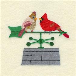 Detailed male cardinal perched on a green weather vane alongside a female cardinal, with a sturdy gray brick base.