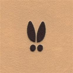 Minimalist rabbit ears and eyes in black thread on light tan, playful design for children's decor.