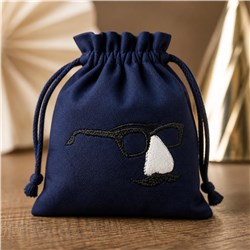 Navy blue drawstring bag features playful embroidery of eyeglasses, a white nose, and a mustache, creating a whimsical charac