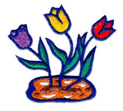 Colorful tulip applique with vibrant purple, yellow, and red flowers amid brown soil and green leaves. Spring theme.
