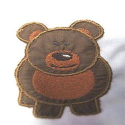 Applique bear with brown fur and a round body, featuring a friendly expression and orange belly.