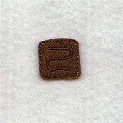Small brown square patch featuring a textured embroidered design in a contemporary style against a light background.